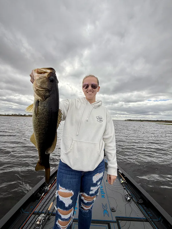 Woman holding her catch on a cloudy day