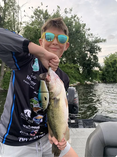 Young guest holding a large bass catch